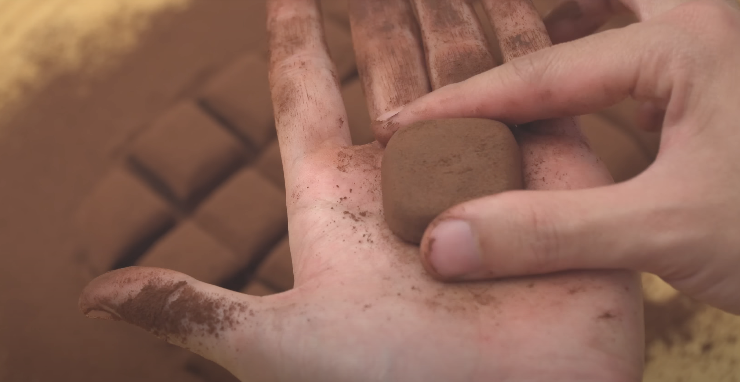 hands shaping chocolate into rounded squares